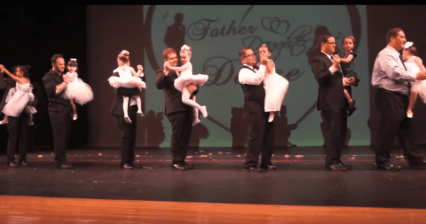 Fathers with their daughters in a country dance number