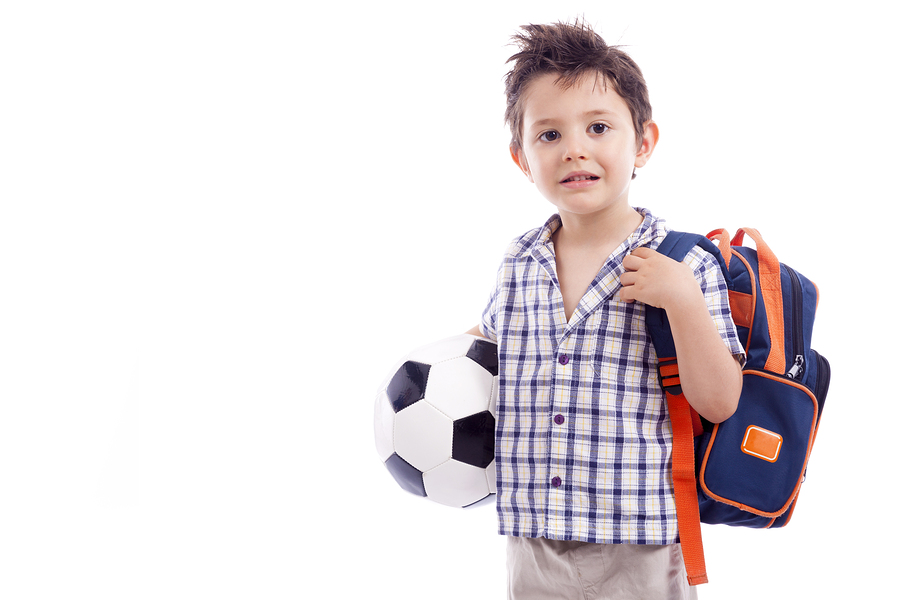Happy school kid holding a soccer ball